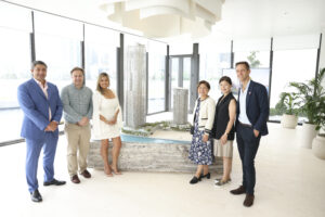 Several people standing near a scale model of a building.